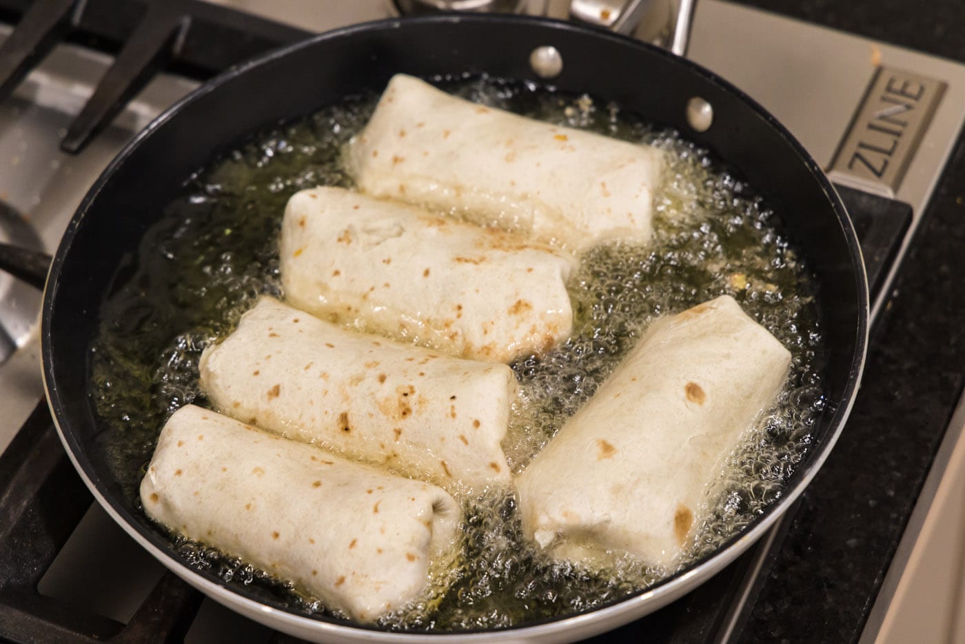 deep frying chimichangas in a skillet