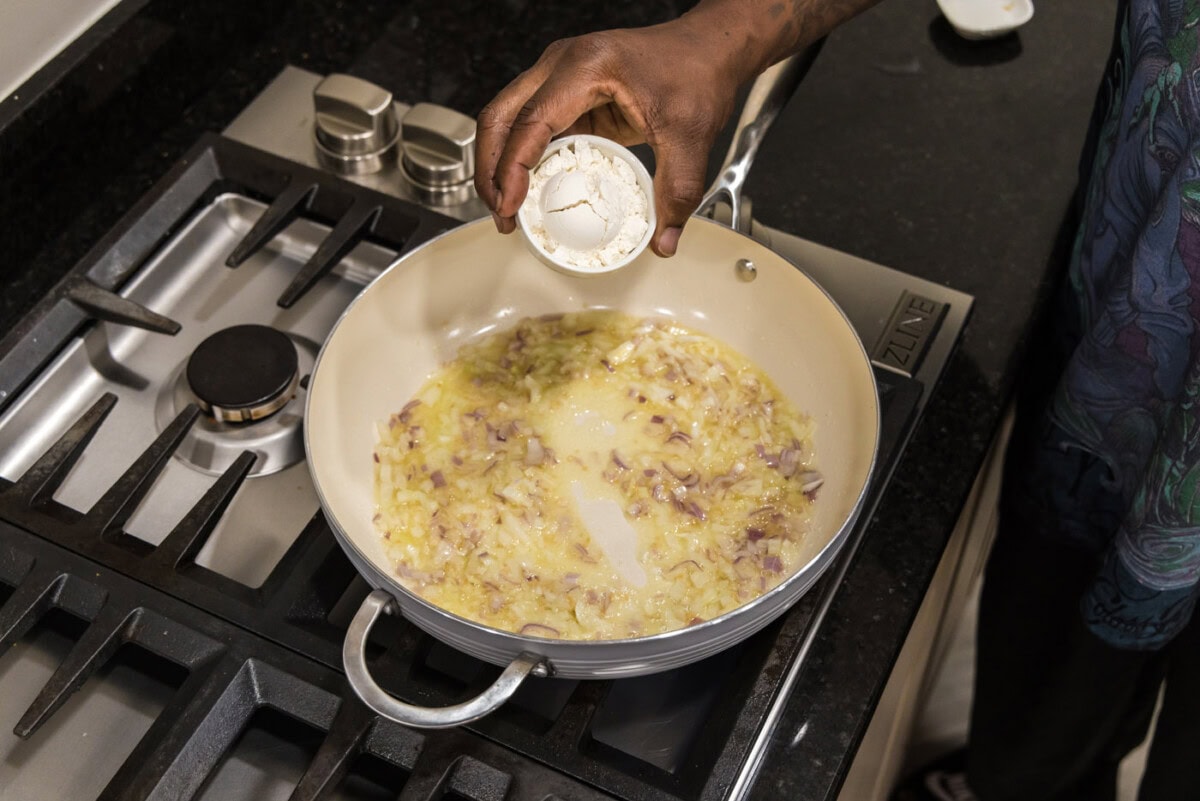 adding flour to skillet to make a roux