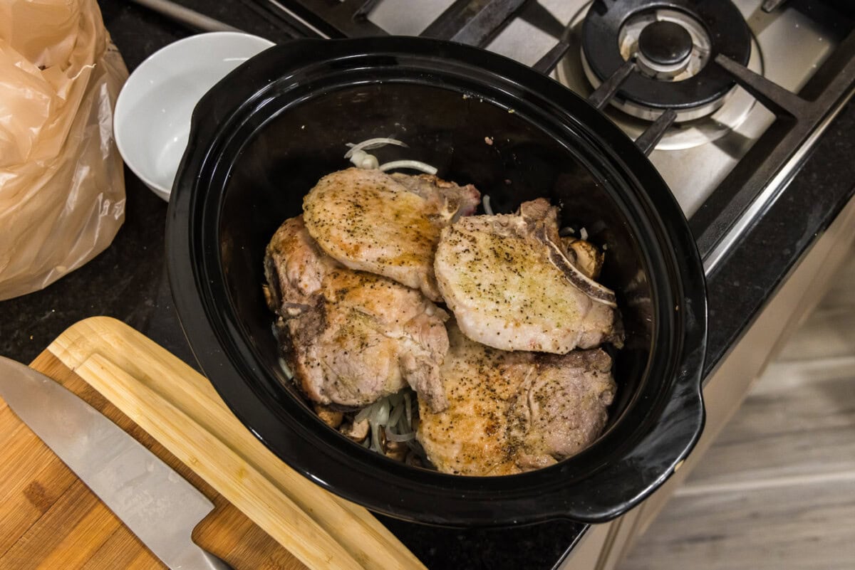 pork chop on top of onions and mushroom