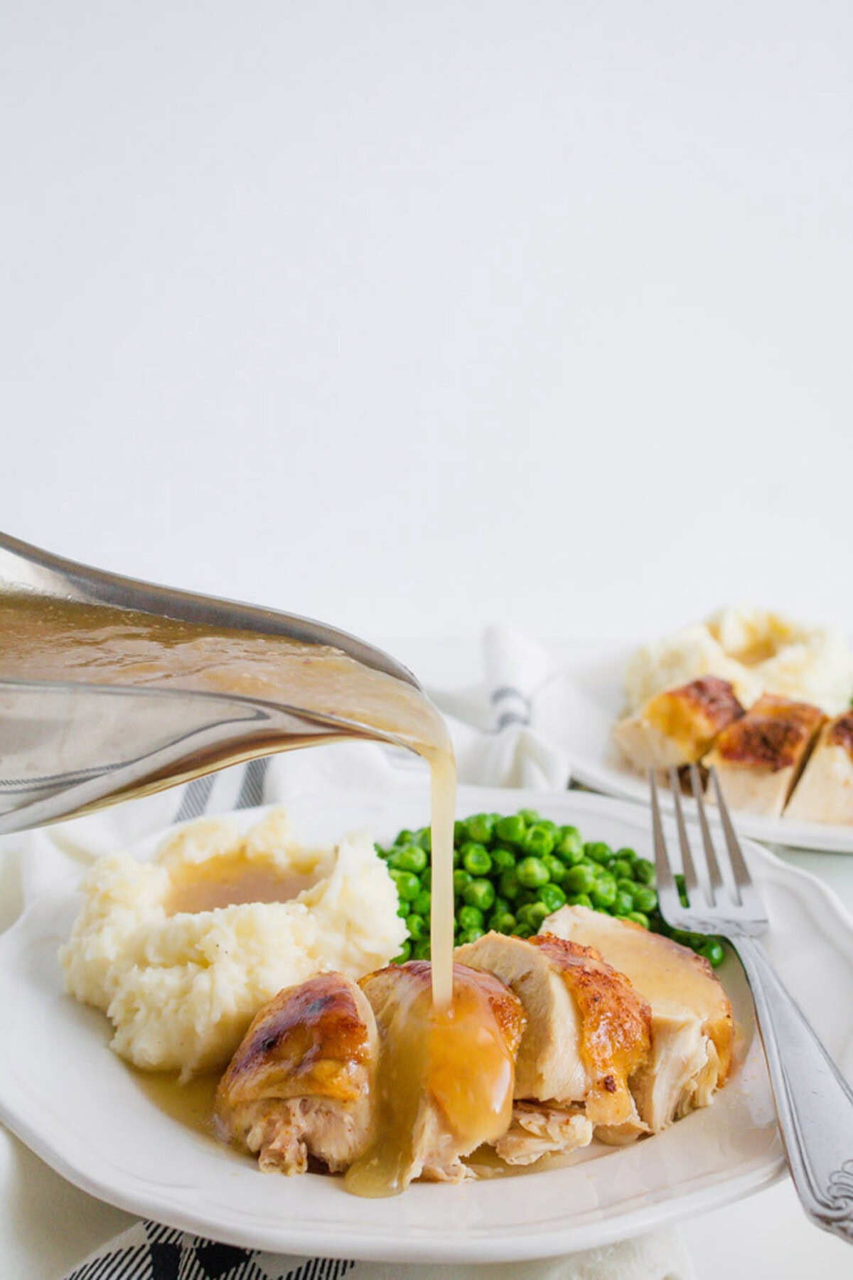 This crockpot chicken recipe is our family's favorite. We make good use of our slow cooker with this spice rubbed sticky chicken at least once a month. Gravy being drizzled on top of Crockpot Sticky Chicken
