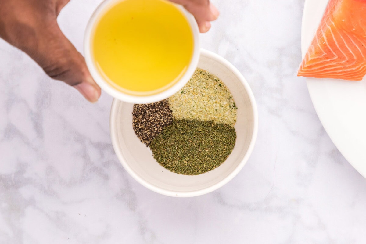 olive oil over a bowl of seasonings