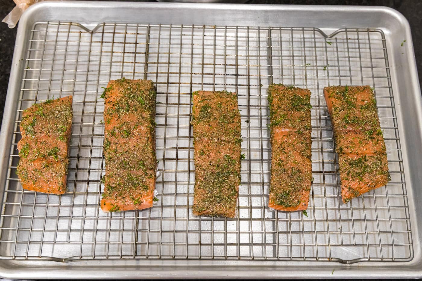 dill salmon filets on a baking sheet with a wire rack