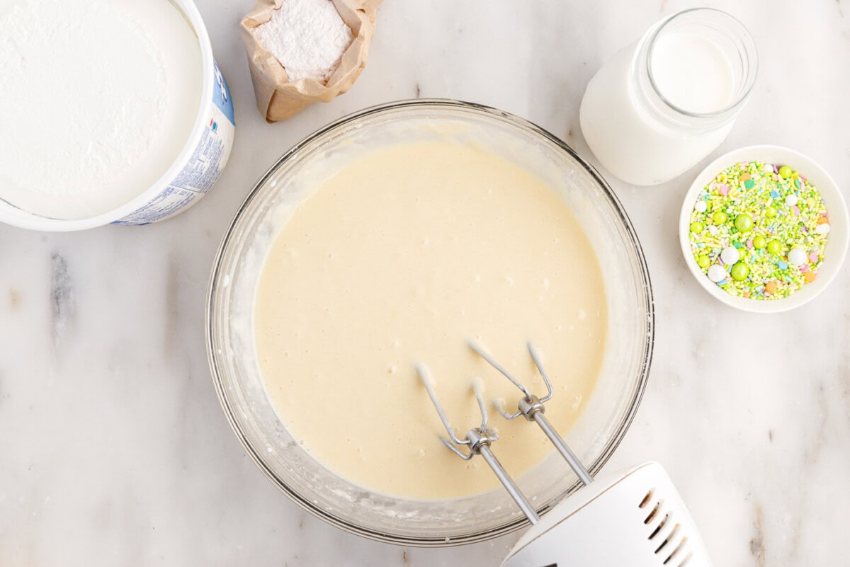 using a hand mixer to beat cake batter