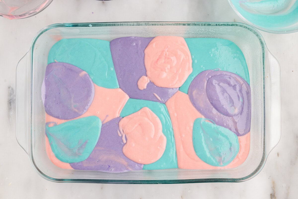 pastel colored cake batter in a baking dish