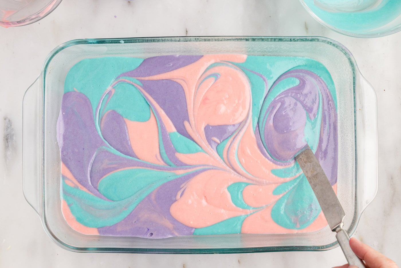 gently swirling colorful cake batter together