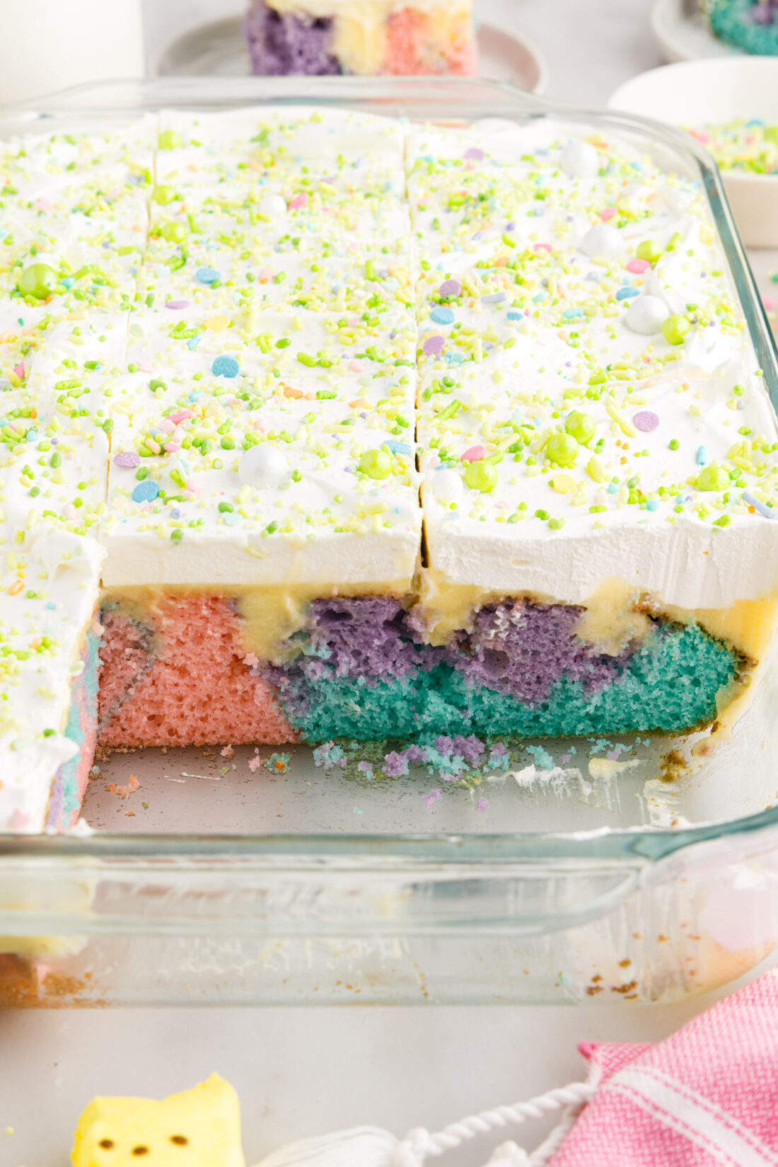 Easter Poke Cake in a 13x9 baking dish with two pieces removed