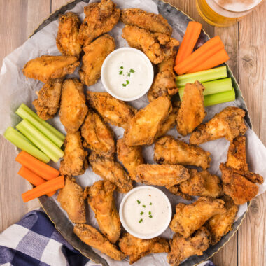 Platter of Fried Chicken Wings with carrots, celery and ranch cups for dipping.