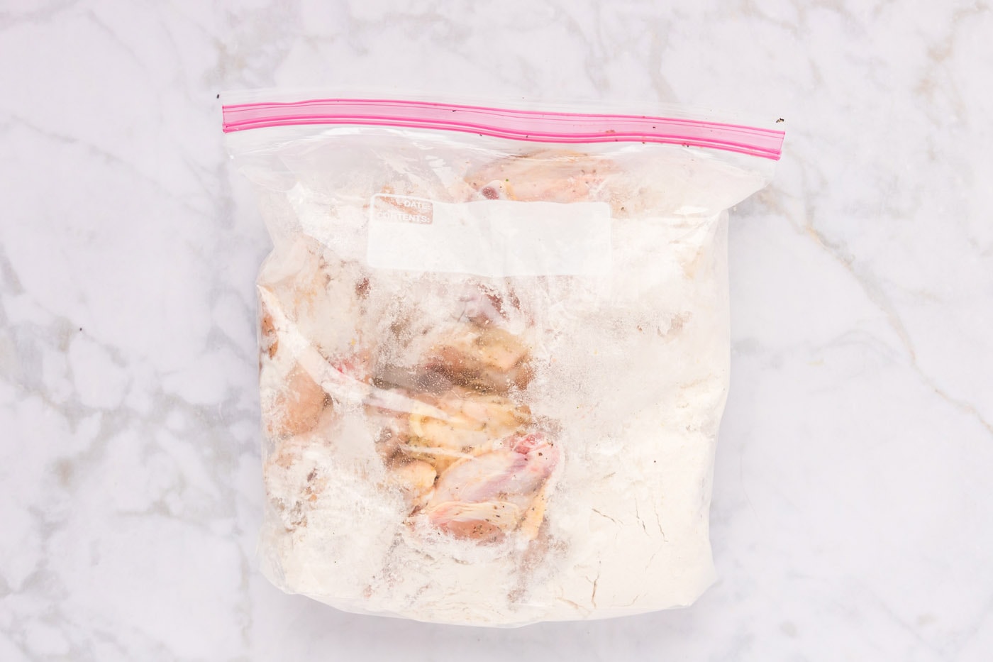 chicken wings in a large zip top bag with flour