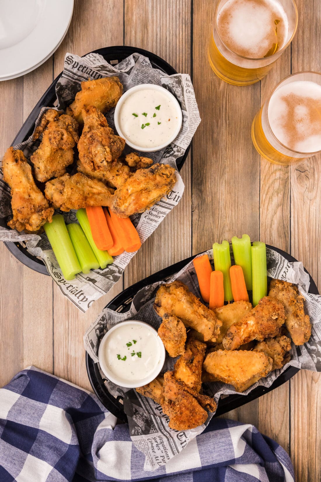Two baskets of Fried Chicken Wings with carrots, celery and ranch.