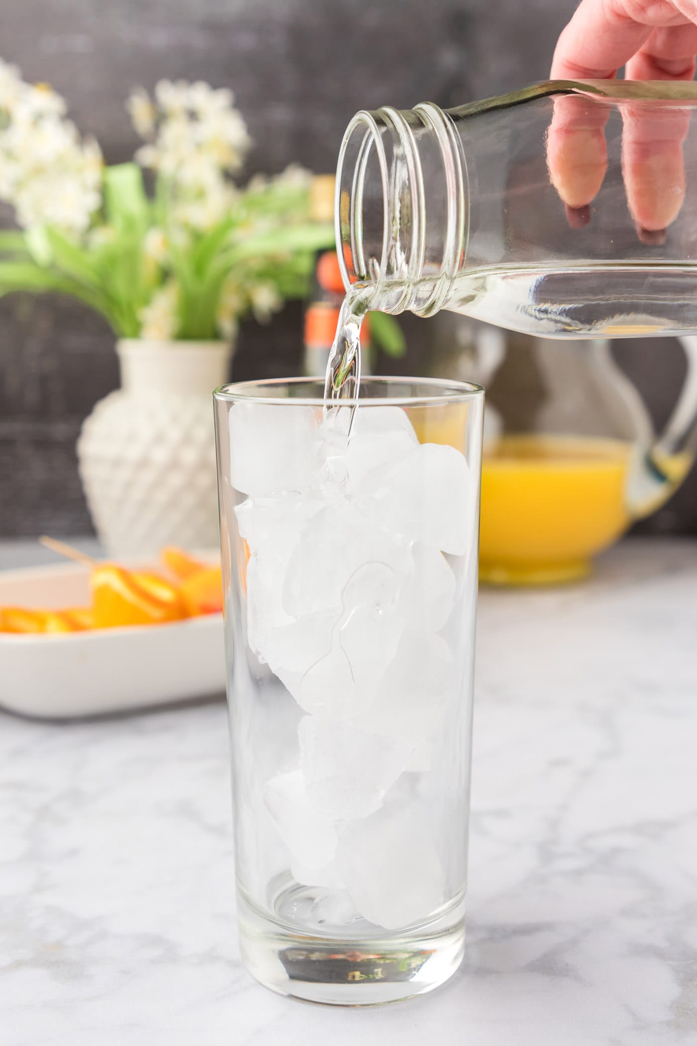 pouring peach schnapps into glass of ice