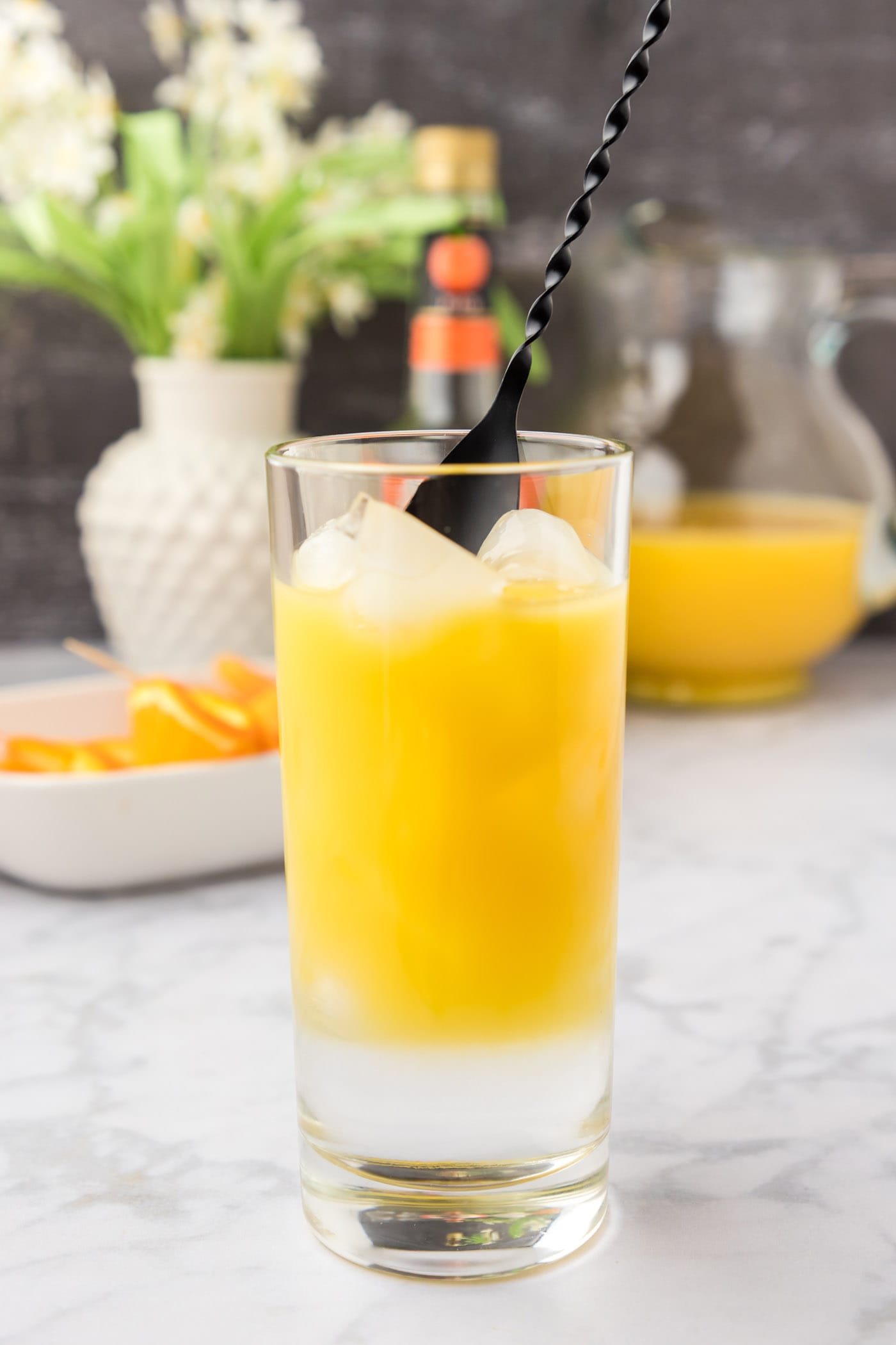 mixing fuzzy navel cocktail in a glass