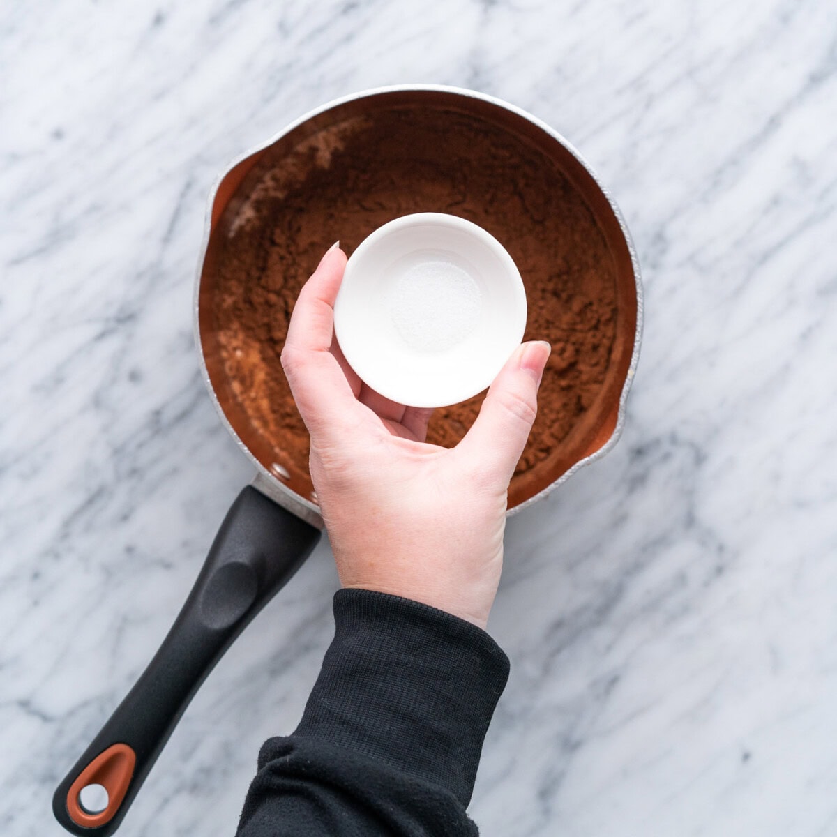 adding corn syrup to chocolate mixture in sauce pan