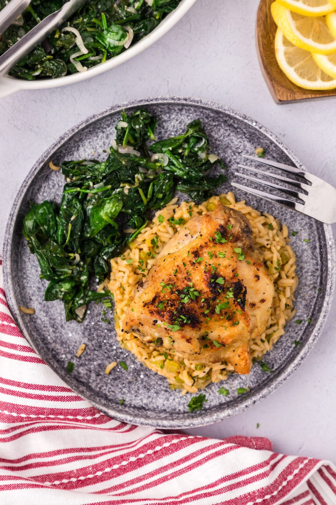 Instant Pot Chicken Thigh on a plate with sautéed spinach