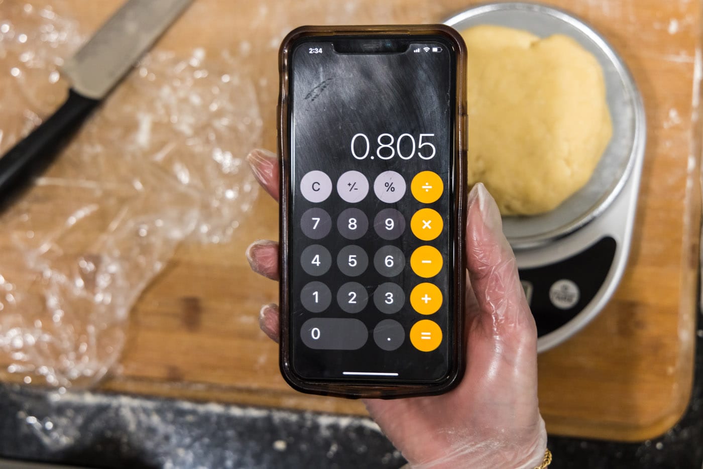 dough on a scale with phone calculator showing weight