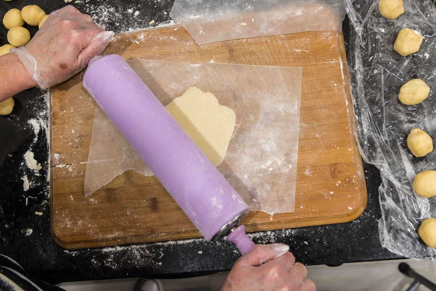 rolling pin flattening pie dough into disc