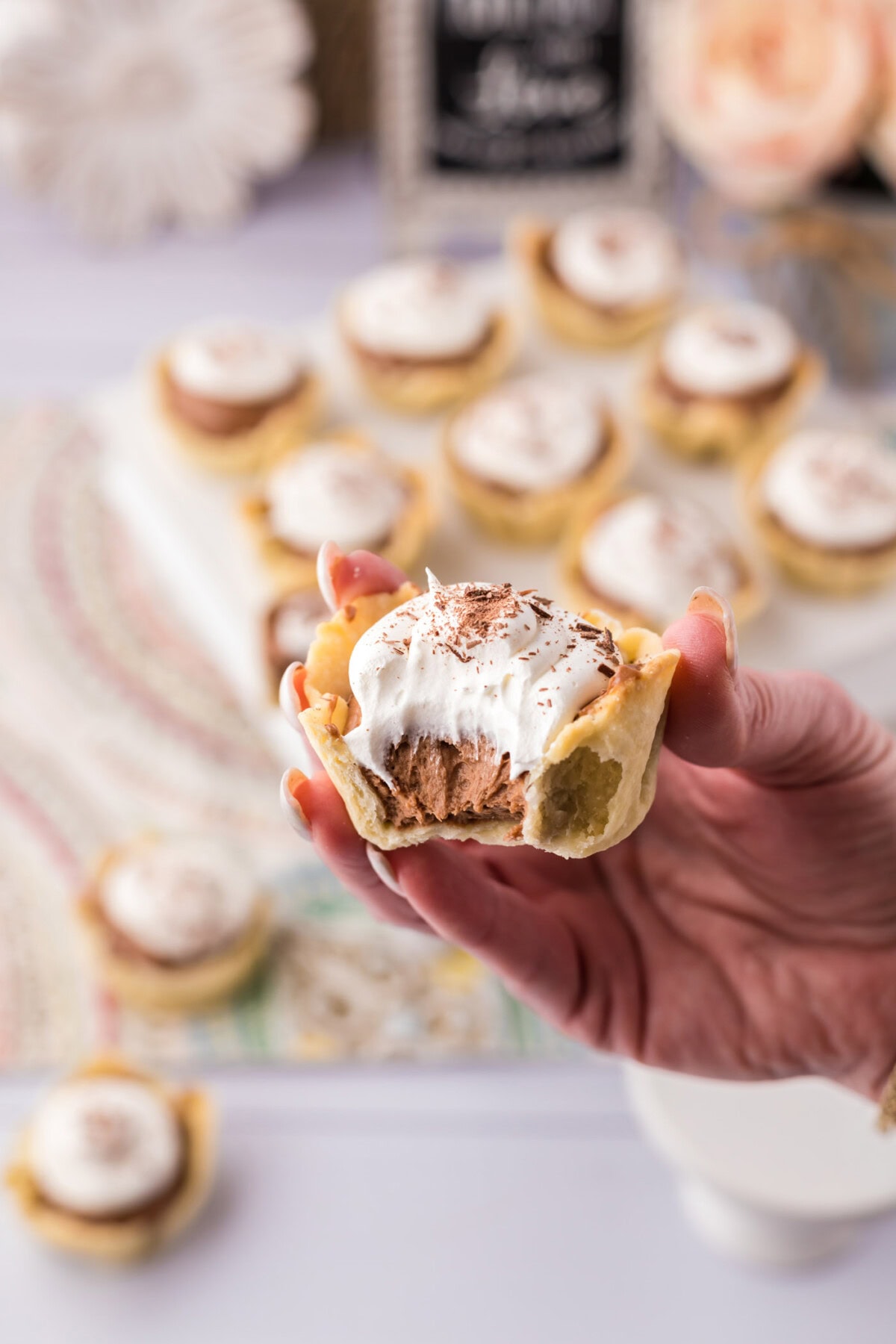 Hand holding a Mini French Silk Pie with a bite taken out