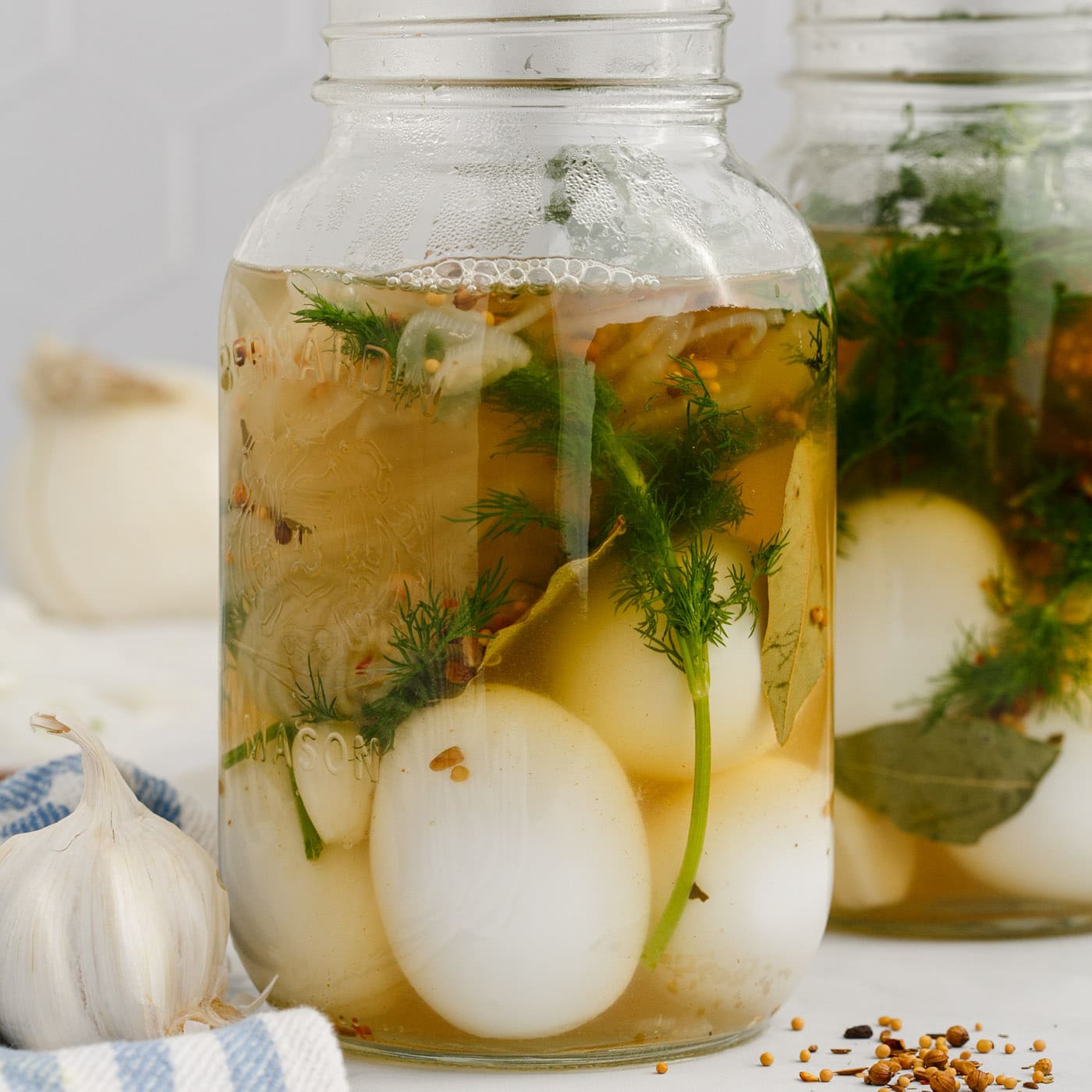 brine added to eggs with herbs in a mason jar