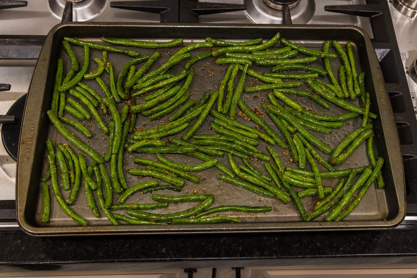 green beans spread out on a baking sheet