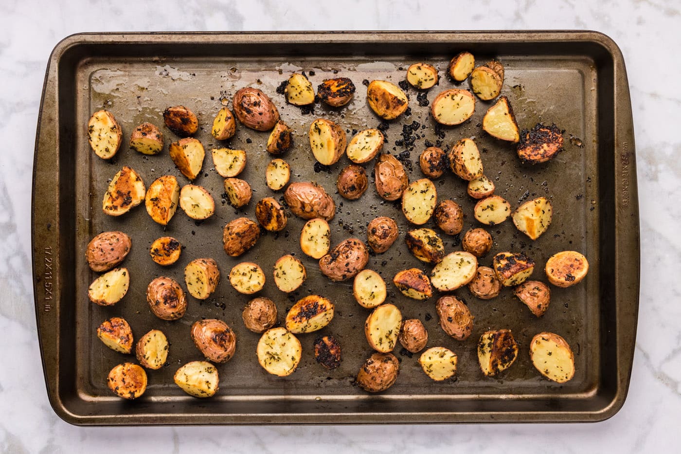 overhead shot of roasted red potatoes on a baking sheet