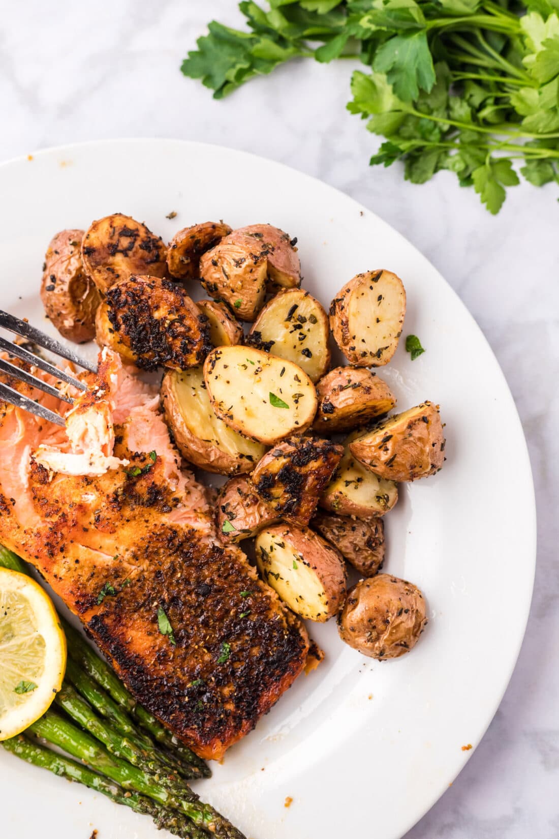 Roasted Red Potatoes on a plate with broiled salmon and asparagus 
