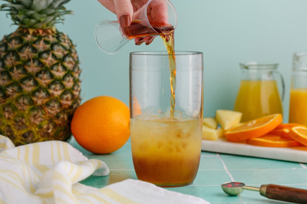 pouring rum into cocktail glass