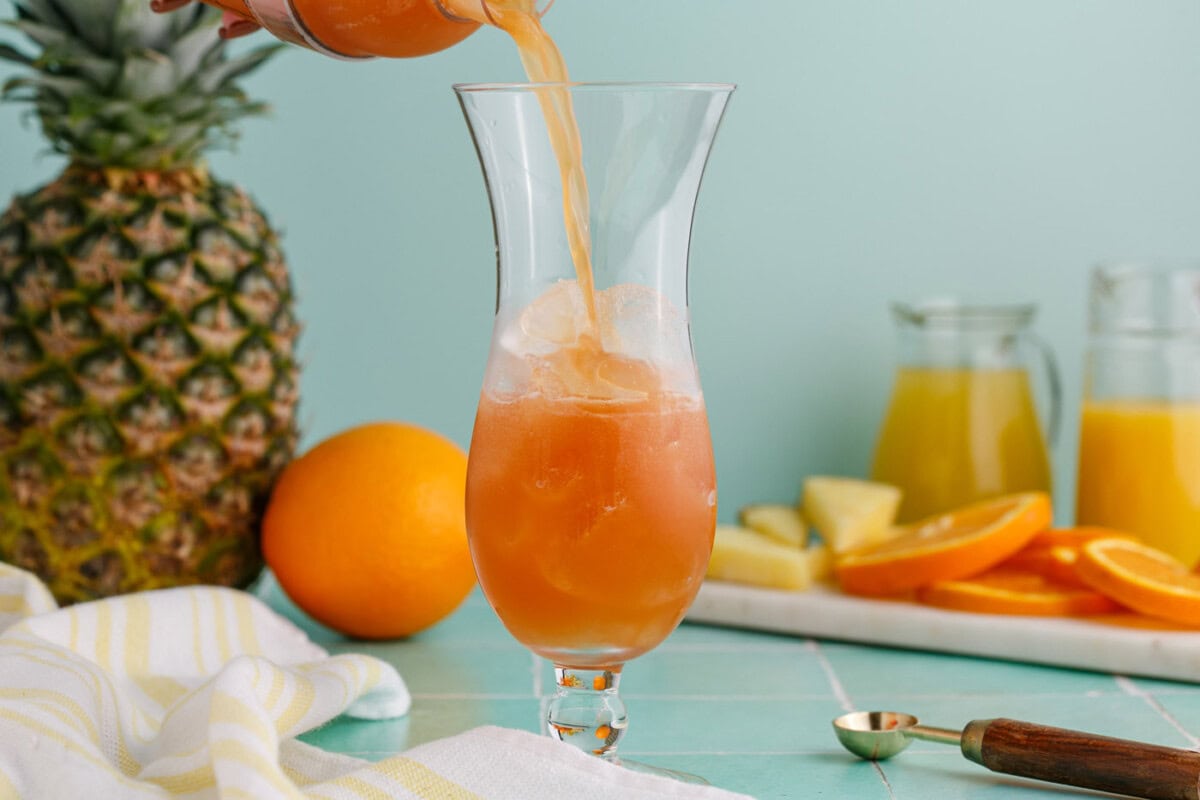 pouring rum runner into a hurricane glass