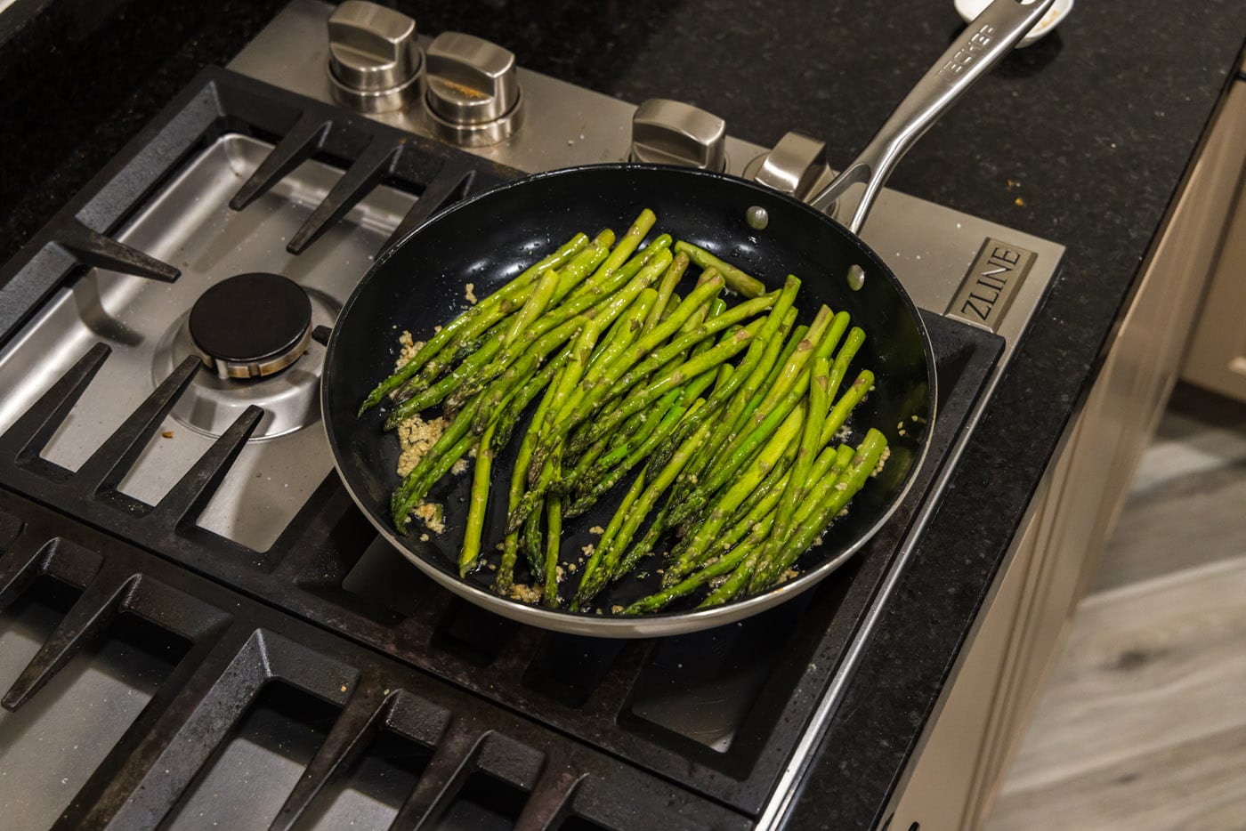 asparagus added to a skillet with olive oil and garlic