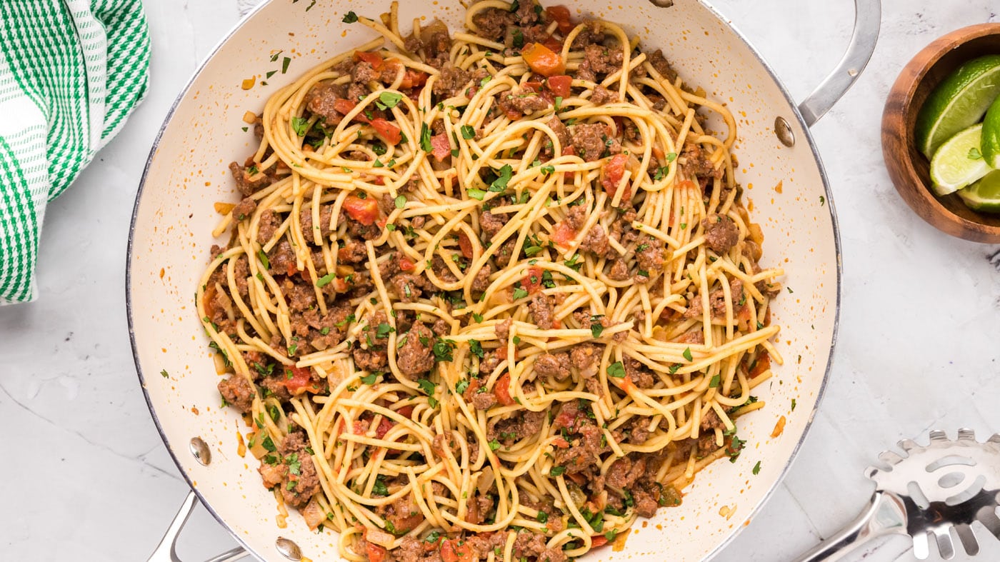 Taco spaghetti couldn't be easier to make, simply cook the noodles, brown the ground beef with chopp