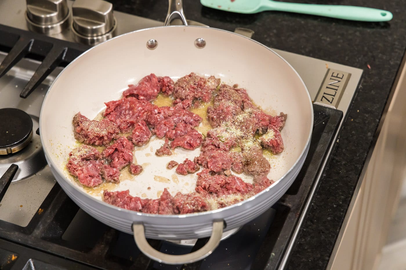 browning ground beef in a skillet with olive oil