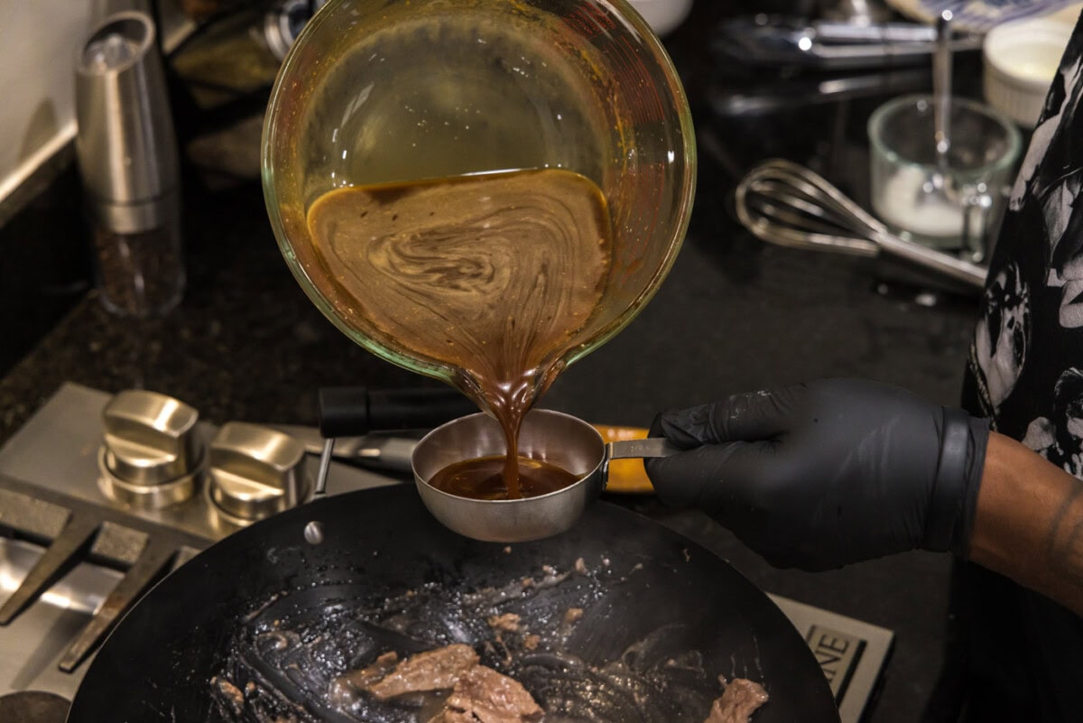 pouring teriyaki sauce into a measuring cup