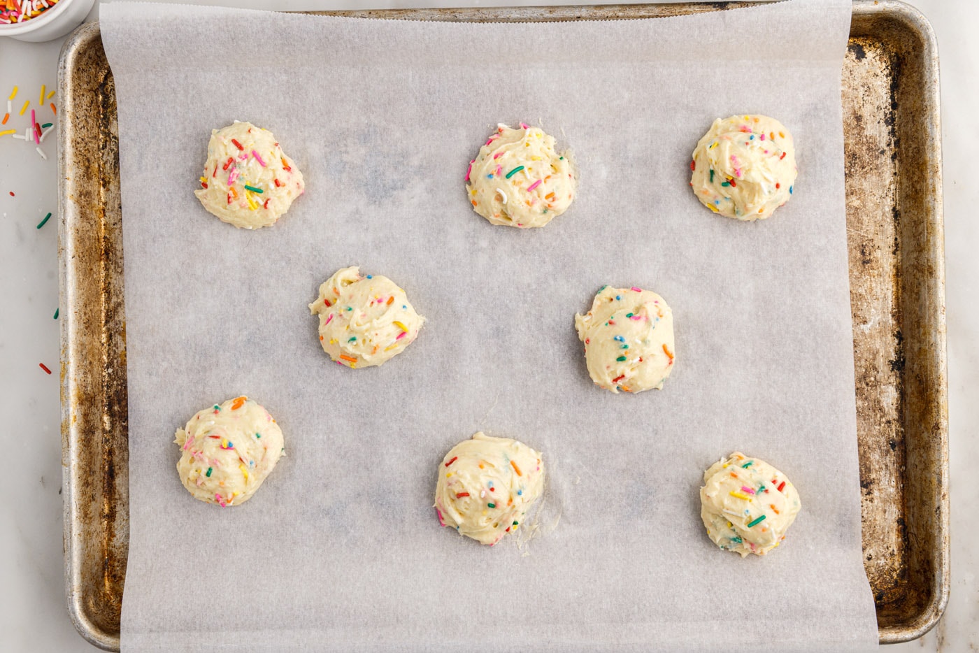 funfetti cookie dough balls on a baking sheet