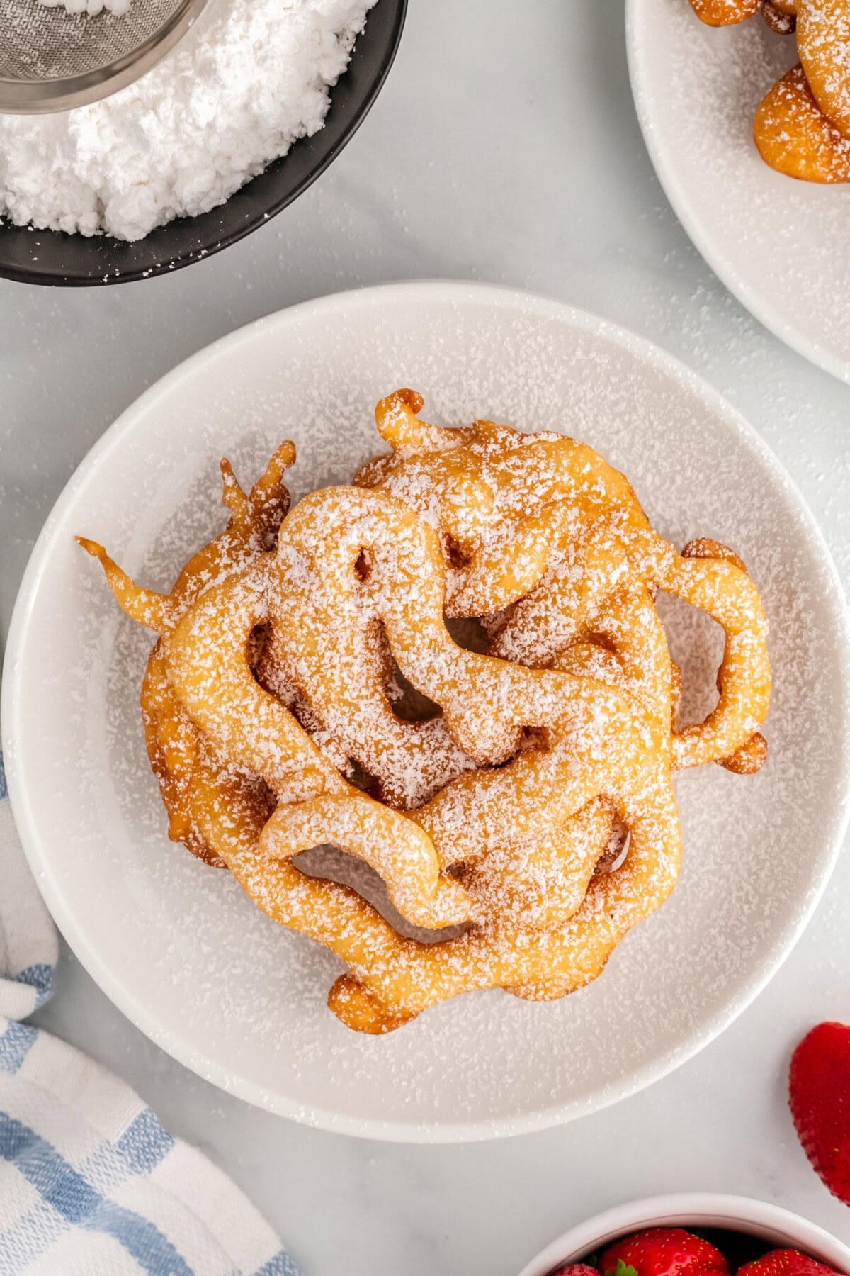Overhead photo of a Funnel Cake topped with powdered sugar
