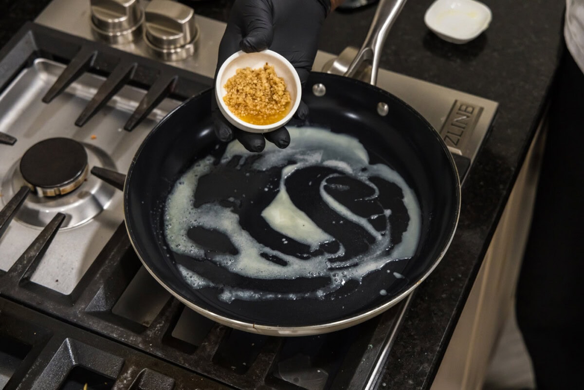 adding garlic to skillet with butter
