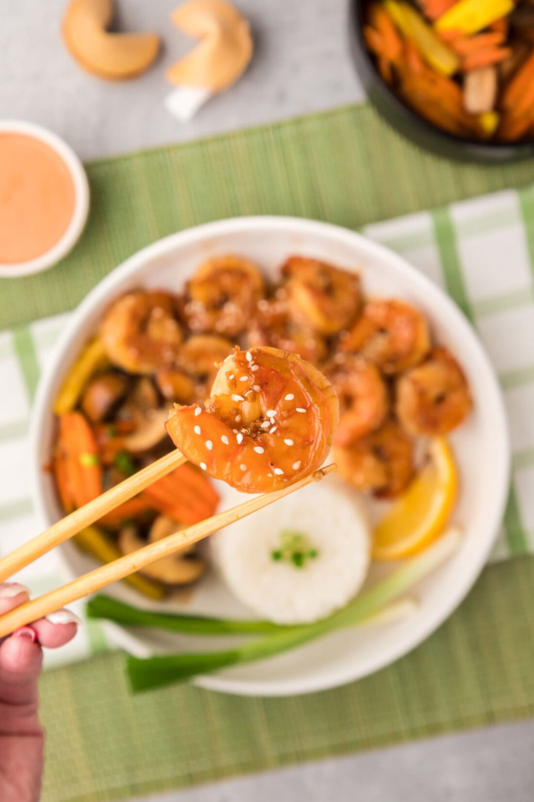 Chopsticks holding up a piece of Hibachi Shrimp