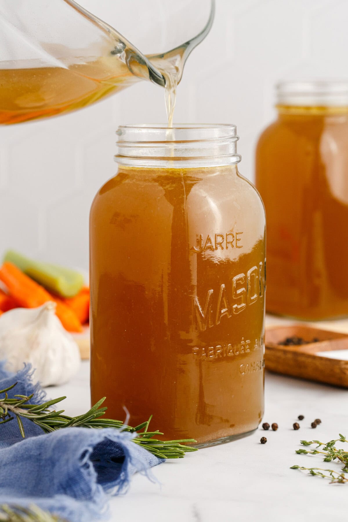Homemade Chicken Stock being poured into a mason jar