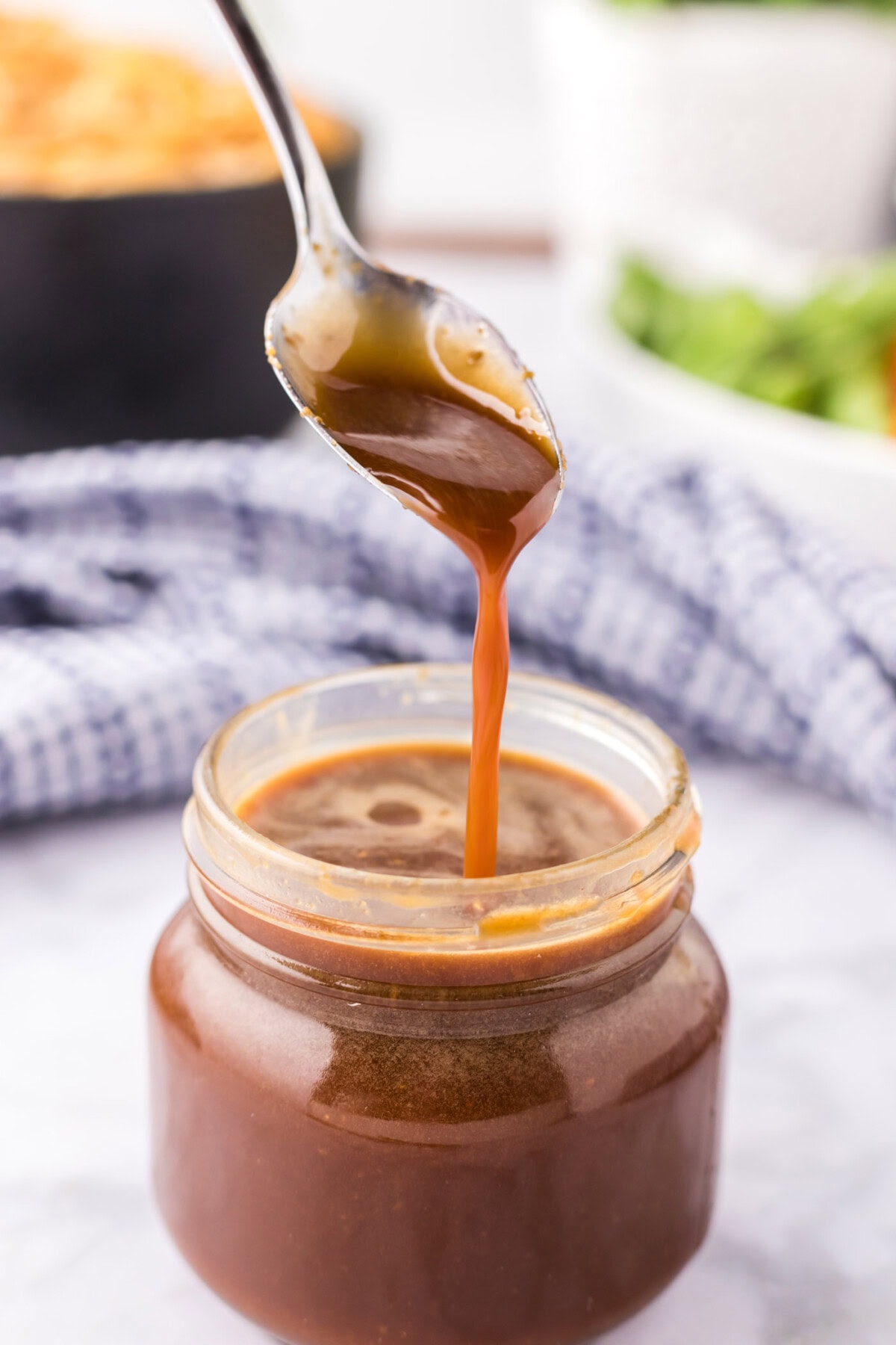Homemade Teriyaki Sauce drizzled from a spoon into a jar
