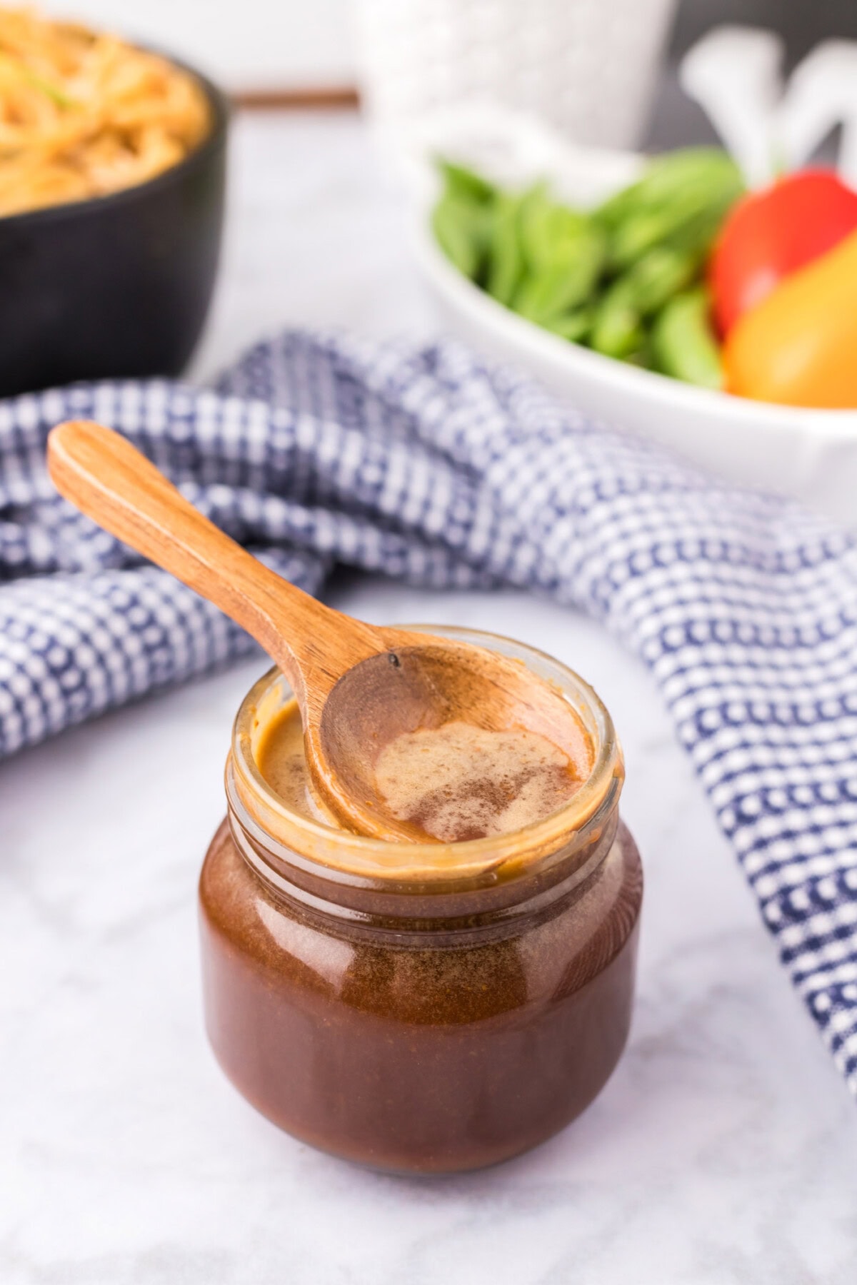 Wooden spoon resting in a jar of Homemade Teriyaki Sauce