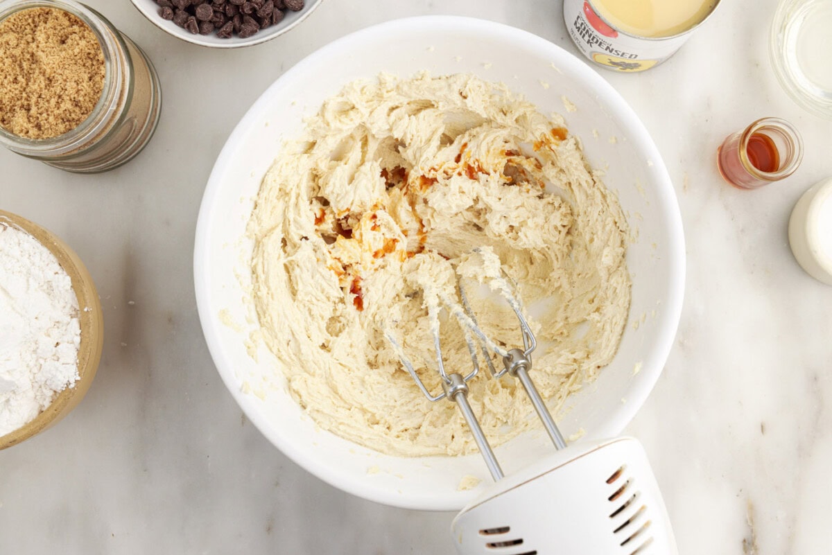adding vanilla to shortbread crust ingredients in a bowl