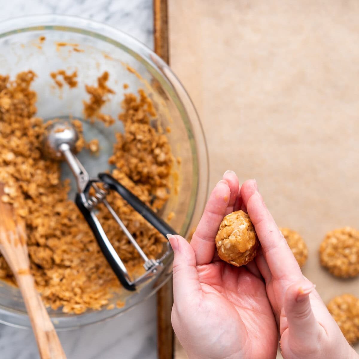 hands pressing dough ball to flatten