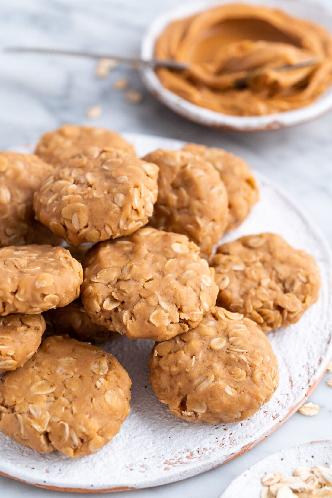 No Bake Peanut Butter Cookies on a plate with peanut butter in the background