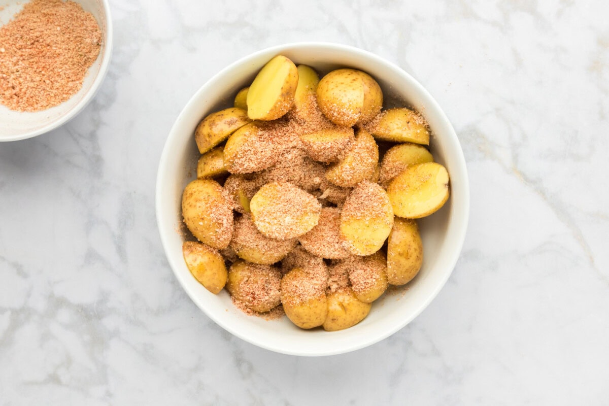 seasoning on top of sliced potatoes with olive oil