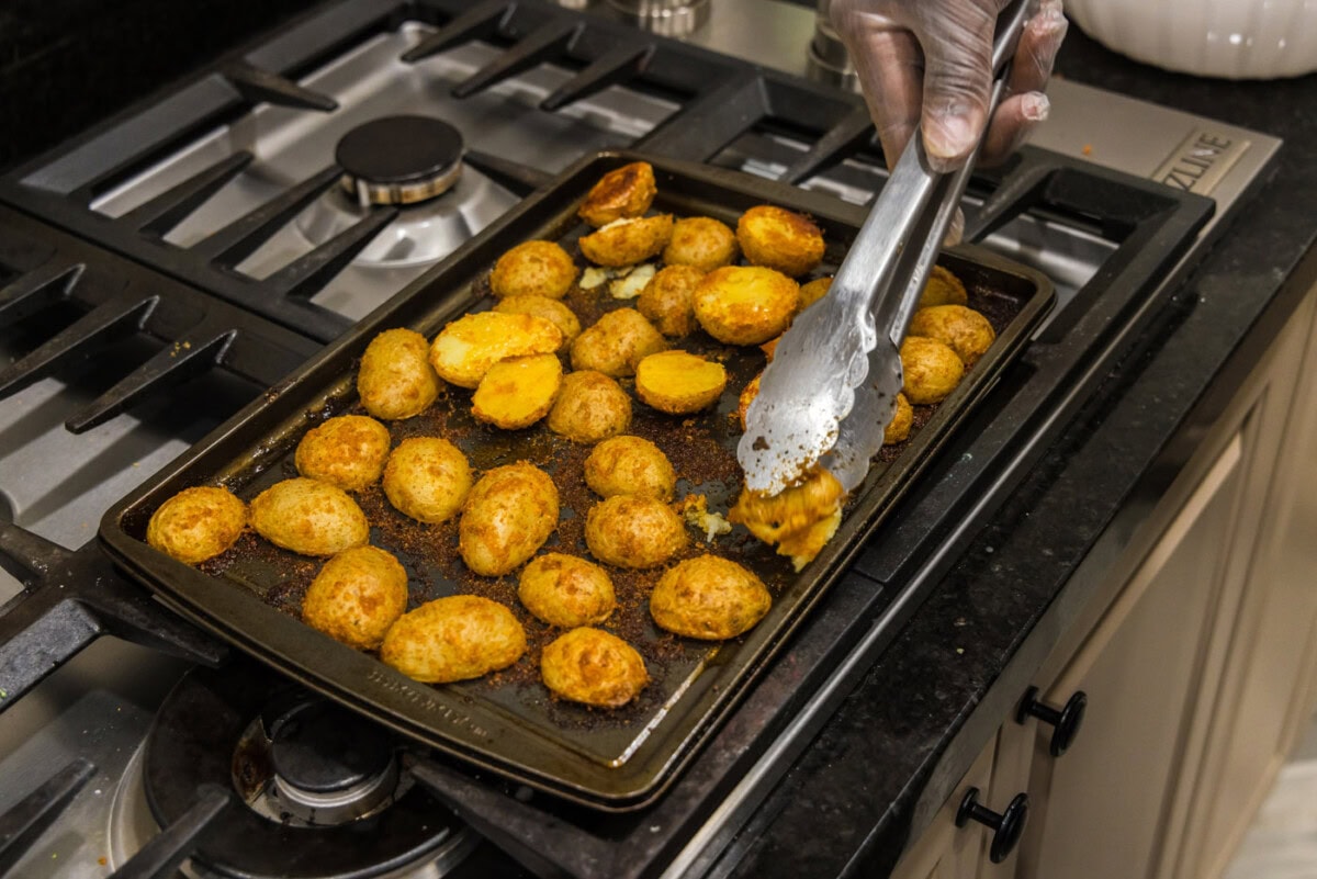 flipping sliced potatoes with tongs