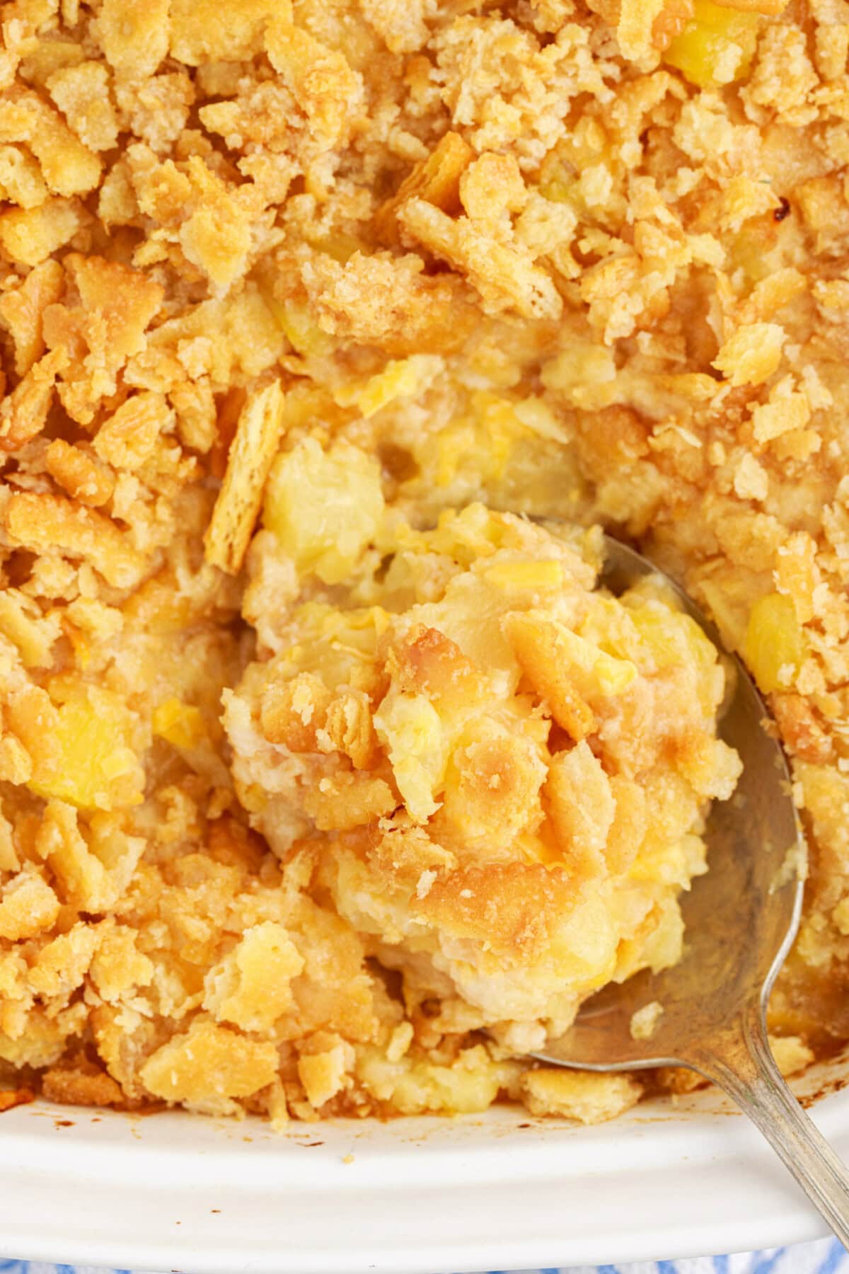 Close up photo of a spoon in a pan of Pineapple Casserole