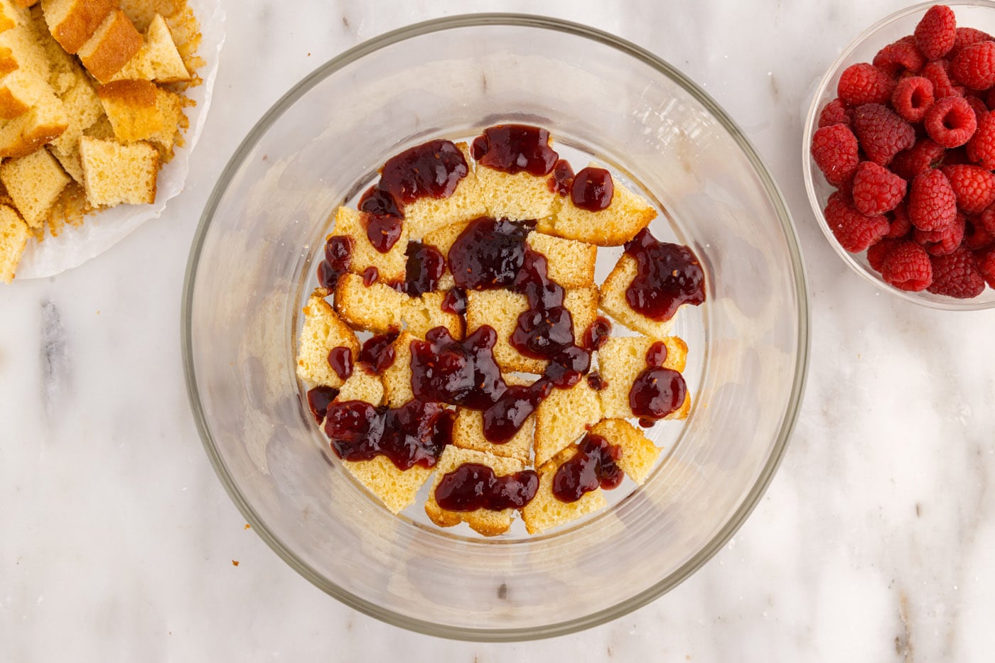 raspberry jam over pound cake in a trifle bowl