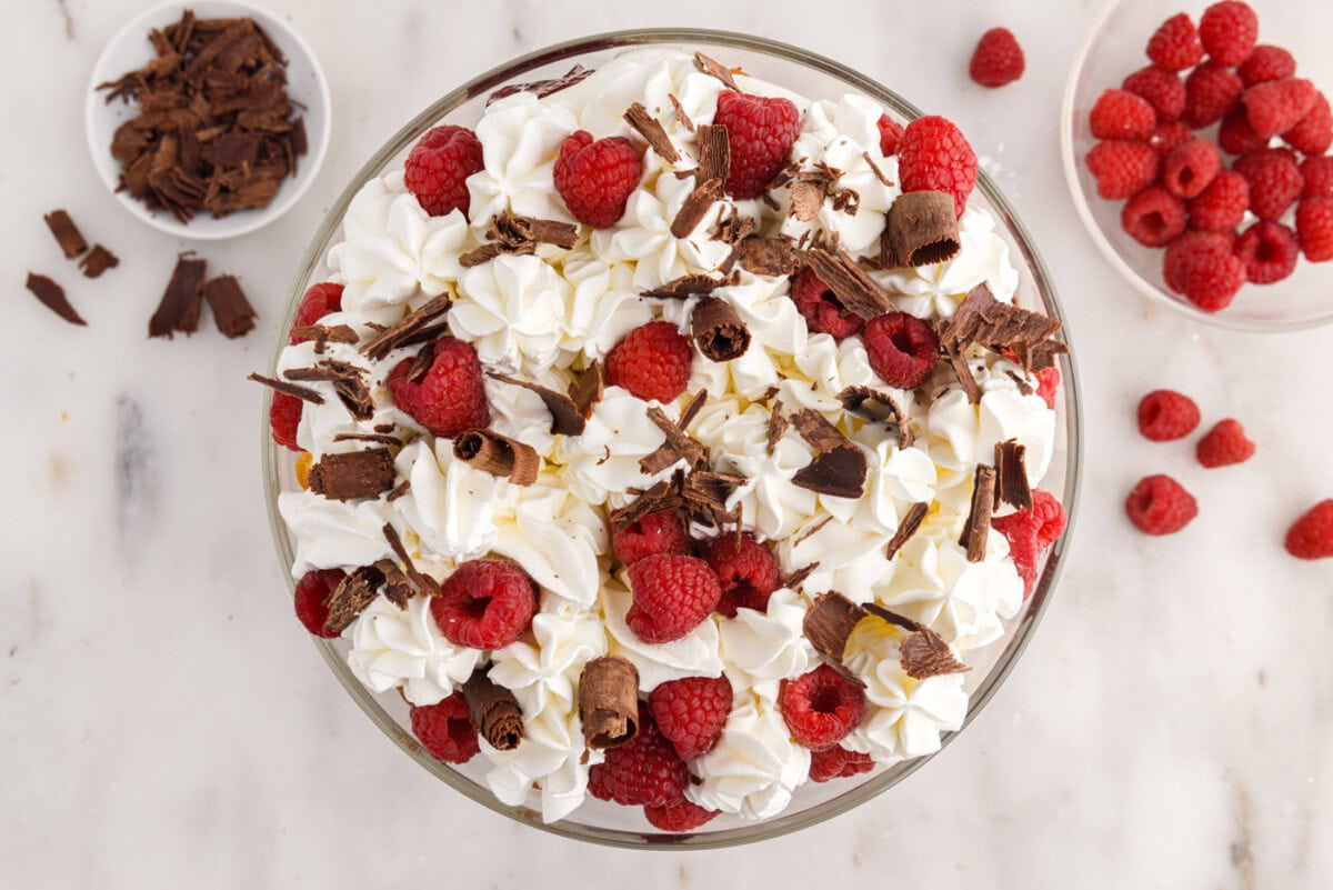 raspberry trifle garnished with fresh raspberries and curled chocolate