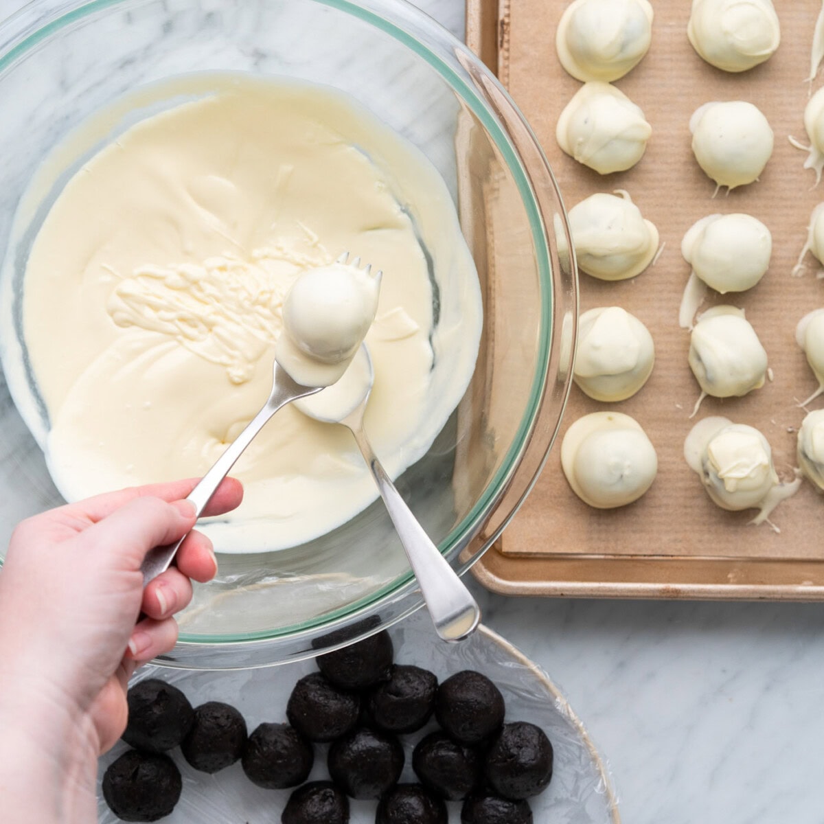 dipping oreo truffles into melted chocolate