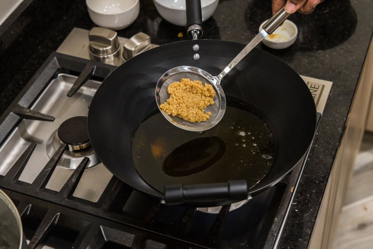 adding minced garlic to hot oil