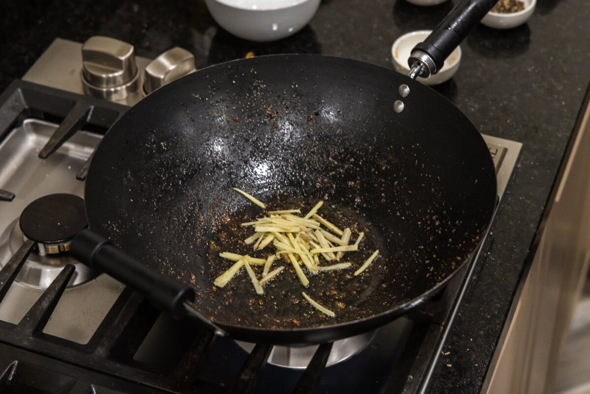 slivered ginger in a wok with oil