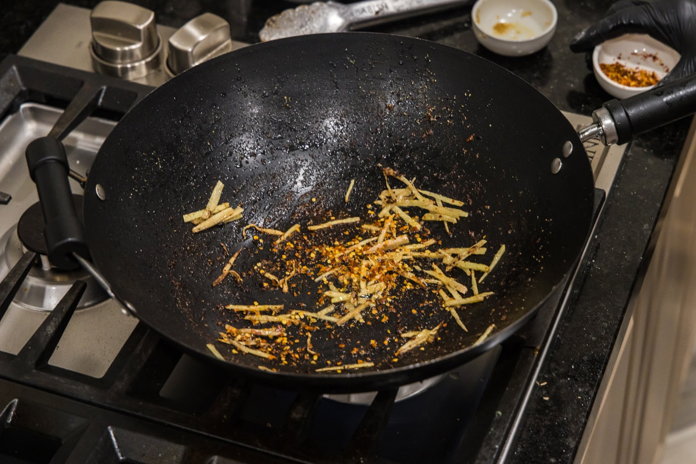 red pepper flakes and slivered ginger in a wok