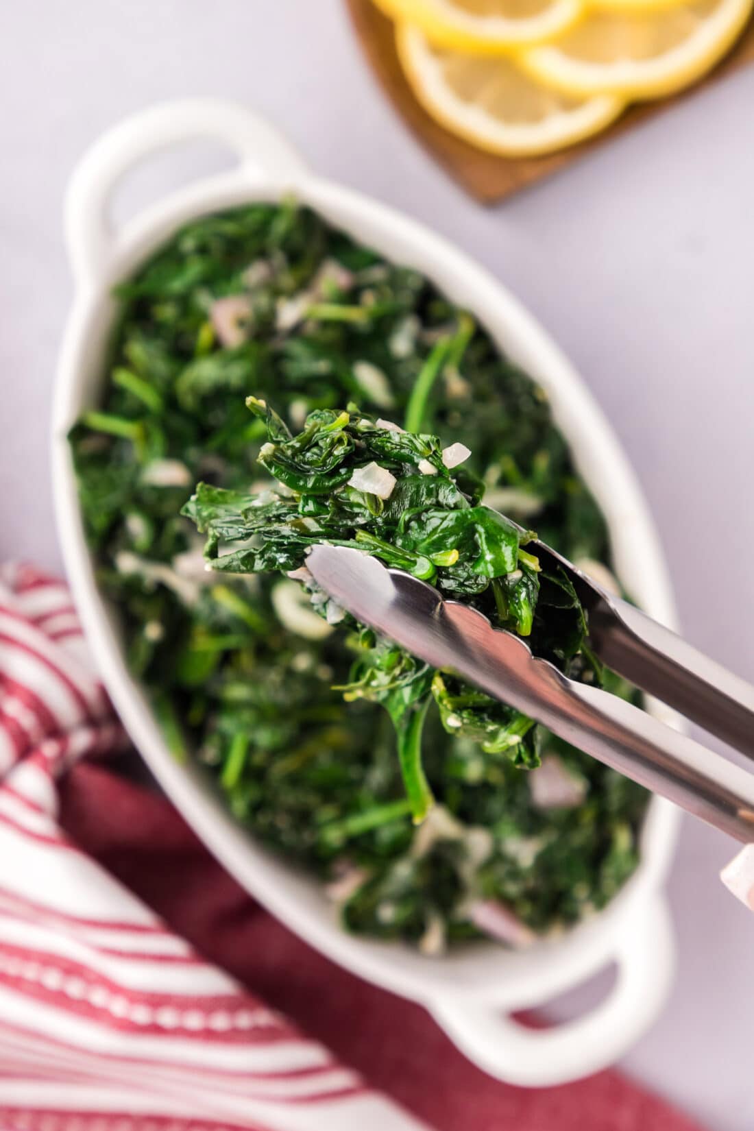 Sautéed Spinach in a pair of tongs